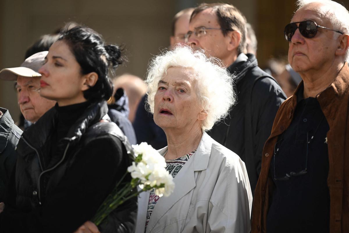 Una mujer sostiene flores mientras hace cola para asistir a una ceremonia de despedida frente al edificio de la Sala de las Columnas, donde se lleva a cabo una ceremonia de despedida del último líder de la Unión Soviética y ganador del Premio Nobel de la Paz en 1990, Mikhail Gorbachev.