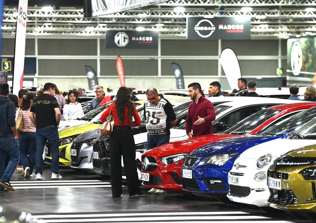 Clientes miran vehículos en la Feria del Automóvil.