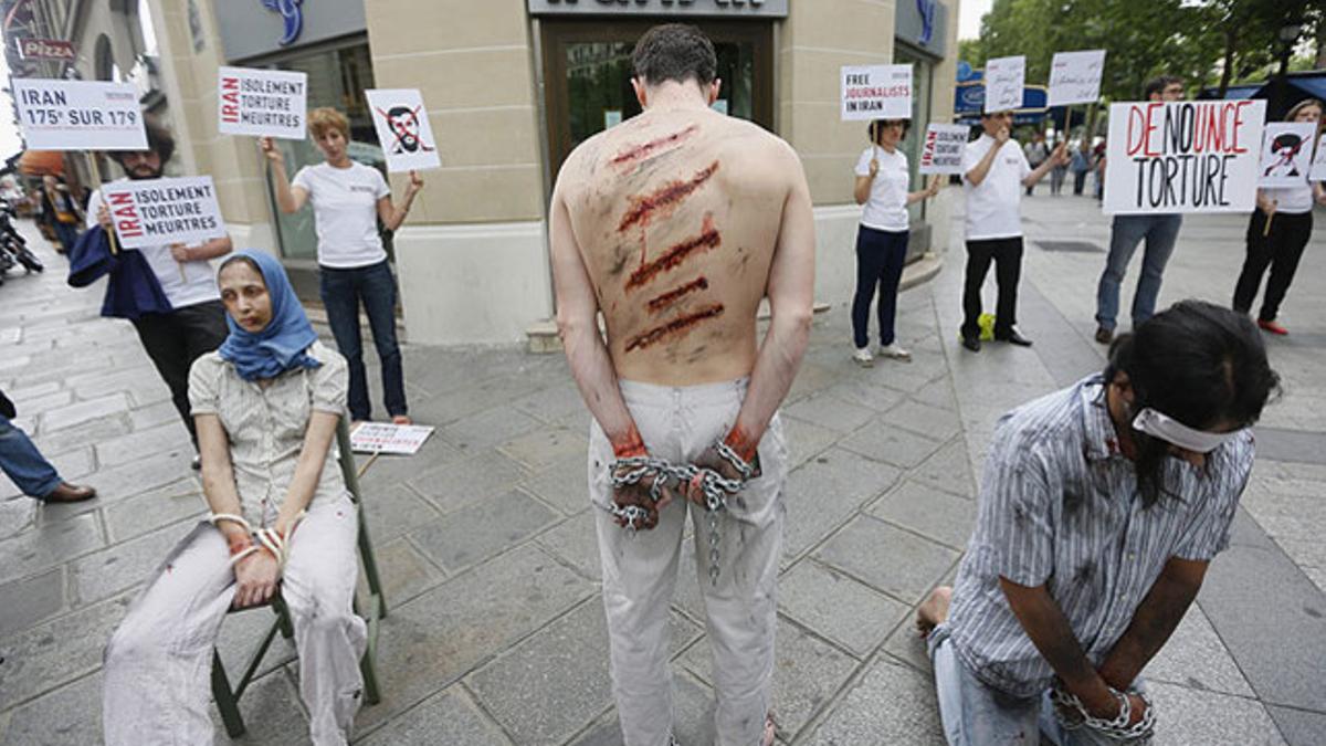 Activistas de Reporteros sin Fronteras (RSF), con heridas simuladas que simbolizan el destino de periodistas detenidos, protestan frente a la sede IranAir, en París.