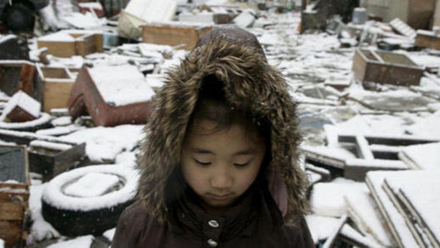 Una niña en medio de una calle llena de escombros en Ishinomaki