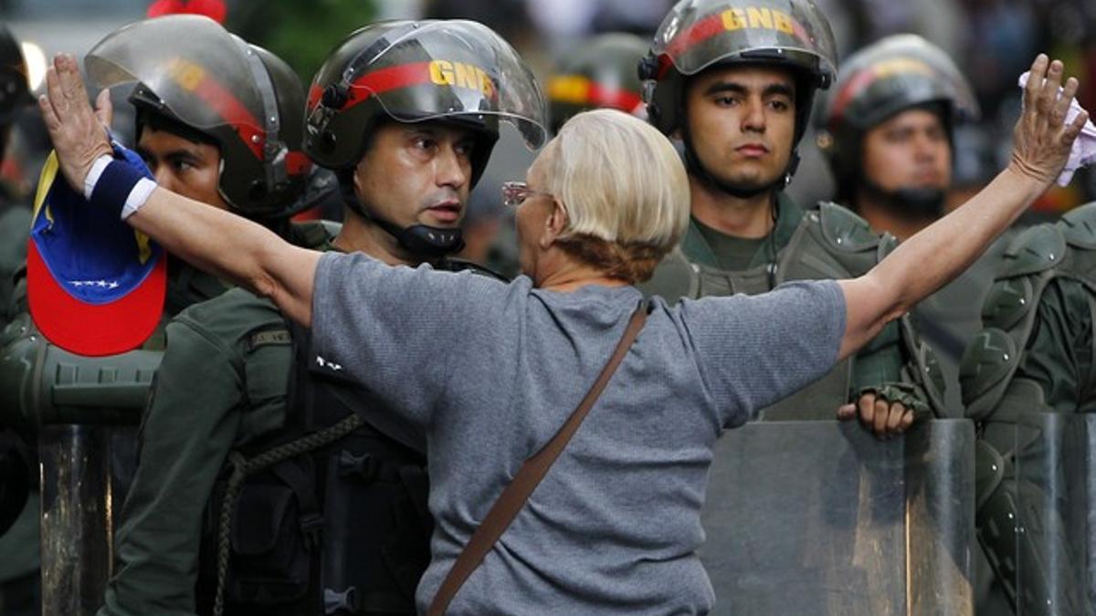 Una manifestante de la oposición se encara con la policía durante una protesta contra el Gobierno de Maduro, el lunes en Caracas.