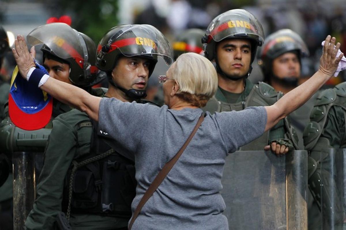 Una manifestant de l’oposició s’encara amb la policia durant una protesta contra el Govern de Maduro, dilluns a Caracas. Una manifestant de l’oposició s’encara amb la policia durant una protesta contra el Govern de Maduro, dilluns a Caracas.
