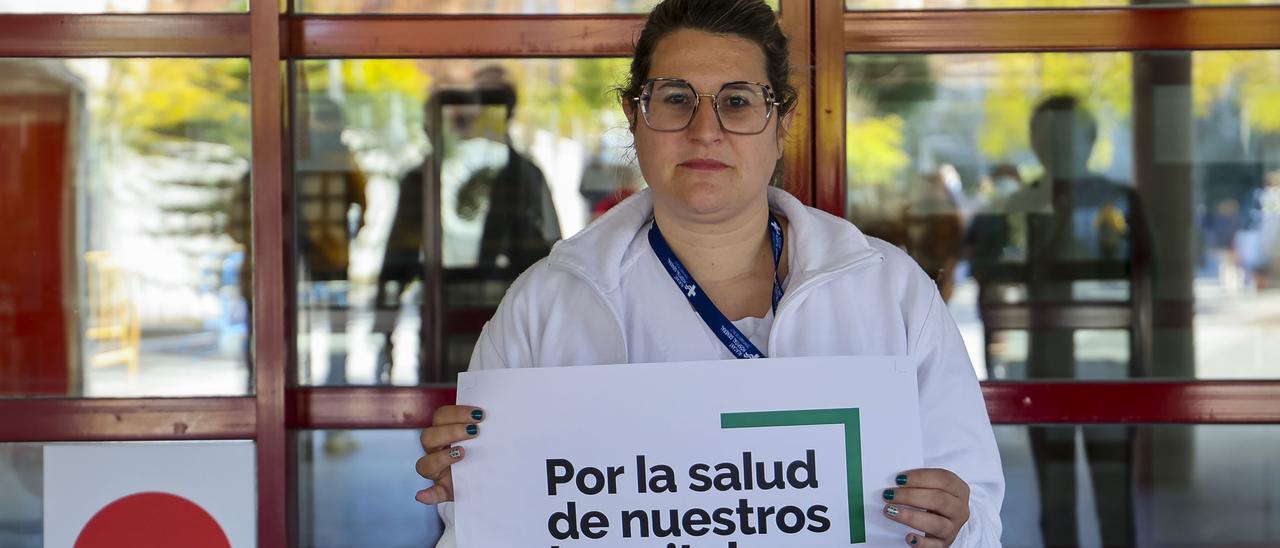 Lara Seva, enfermera de Traumatología, a las puertas del hospital con el cartel de la concentración de protesta.