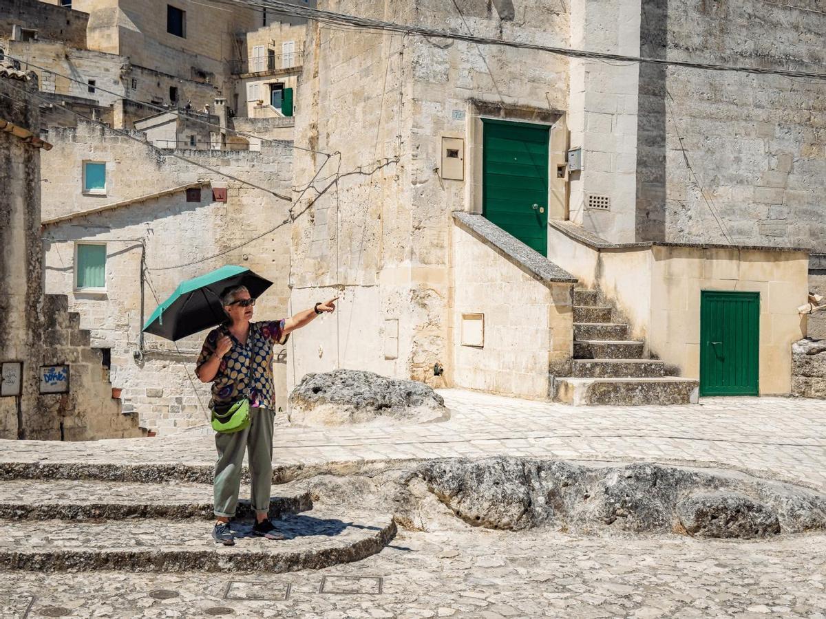 Matera, Italia. Una guía turística cuenta la historia de los Sassi mientras señala alguno de los rincones de esta ciudad excavada en la roca. Matera fue habitada durante miles de años en estas viviendas rupestres, antes de que sus habitantes fueran trasladados a nuevos barrios a mediados del siglo XX. (iPhone 16 Pro Max)