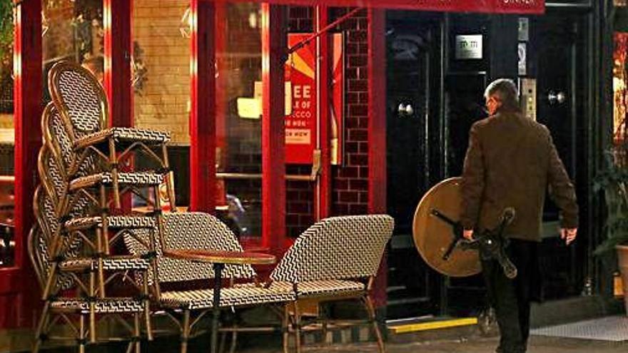 Un home recull la terrassa d&#039;un restaurant al centre de Londres.