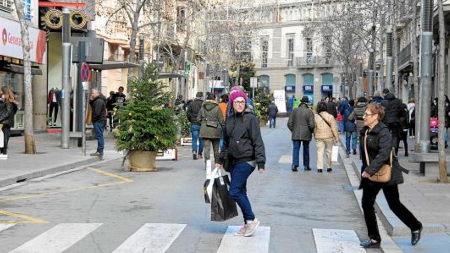 Vianants passejant pel carrer Guimerà de Manresa ahir al migdia. Tot i que s&#039;ha tret el trànsit de la via, són pocs els que circulen per fora de les voreres