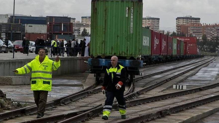 Dos operarios coordinan la llegada del tren a la terminal ferroviaria del puerto en el muelle 23. Hoy regresa a Madrid