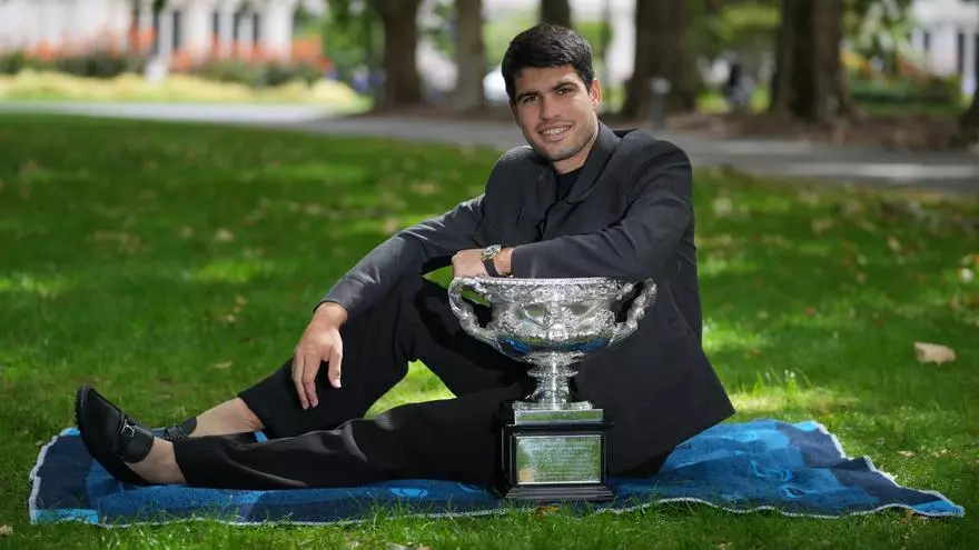 Alcaraz celebra su victoria en el Open de Australia posando con el trofeo