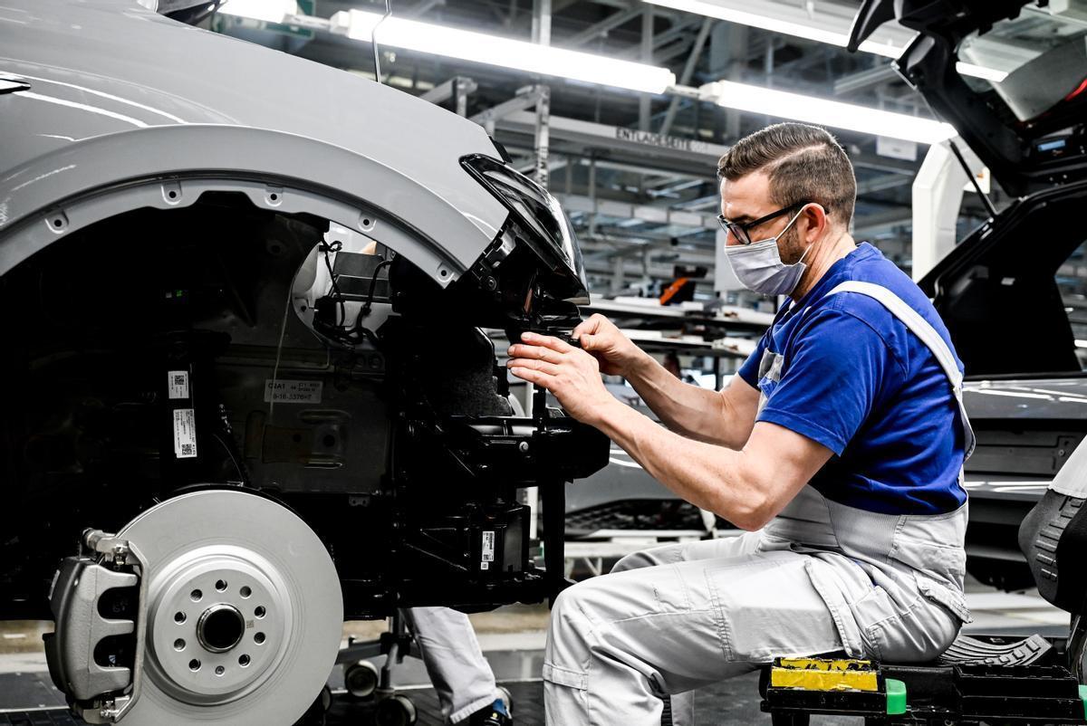 Un empleado de Volkswagen trabaja en una línea de montaje de coches eléctricos en Alemania.