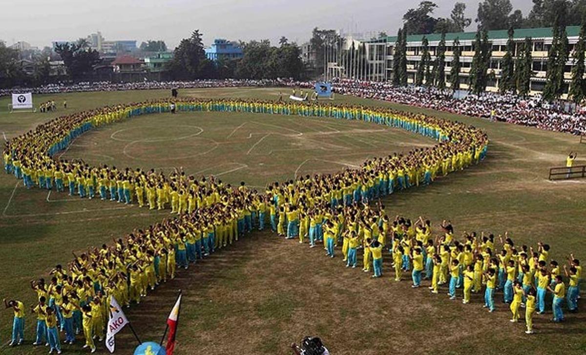 Estudiants de l’Escola Secundària Rizal (Manila), durant una actuació en la qual formen un llaç groc gegant per commemorar el 25 aniversari de la revolució popular que va enderrocar la dictadura de Ferdinand Marcos, a Filipines.