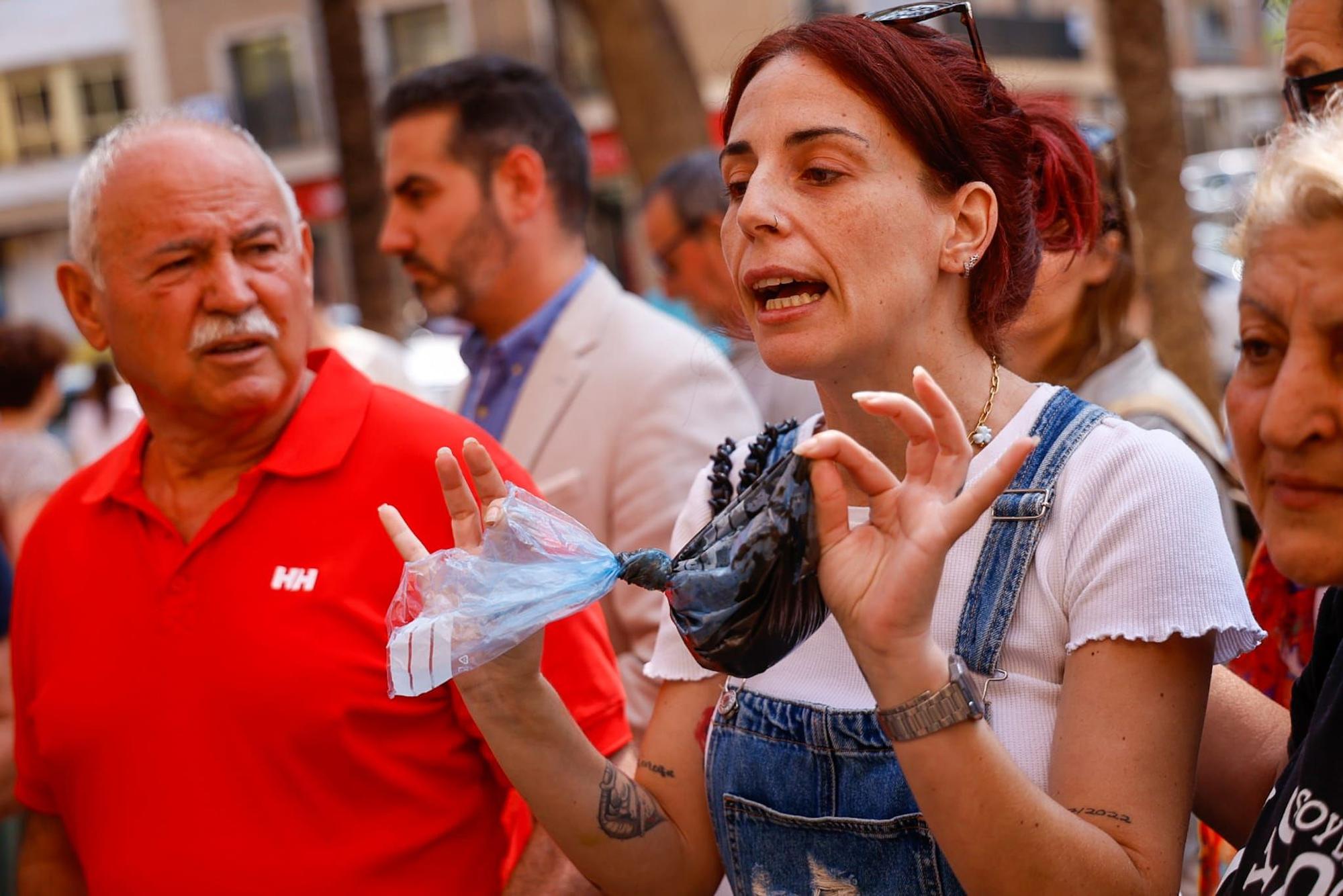 Una vecina de Catarroja lleva una bolsa de fango de la dana a la visita del ministro y Bernabé