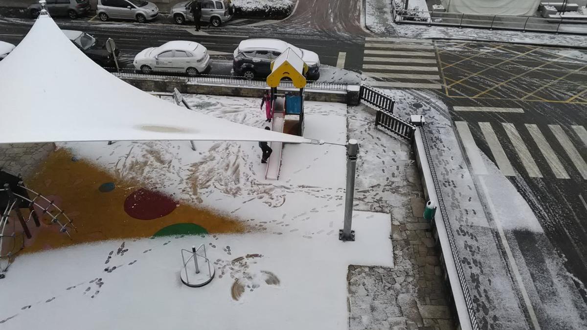 El parque infantil de Teixeiro, nevado este lunes.