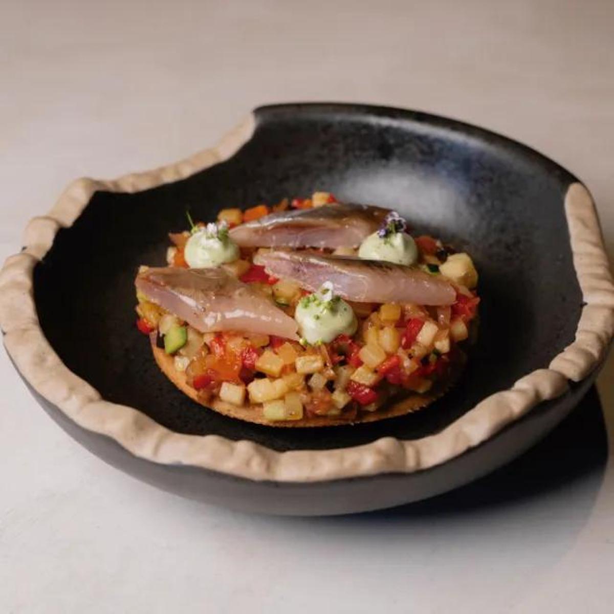 Dos Trazos Mallorca (Sa Pobla) presenta una coca de xeixa, tumbet, sardina ahumada y alioli de hierbabuena.