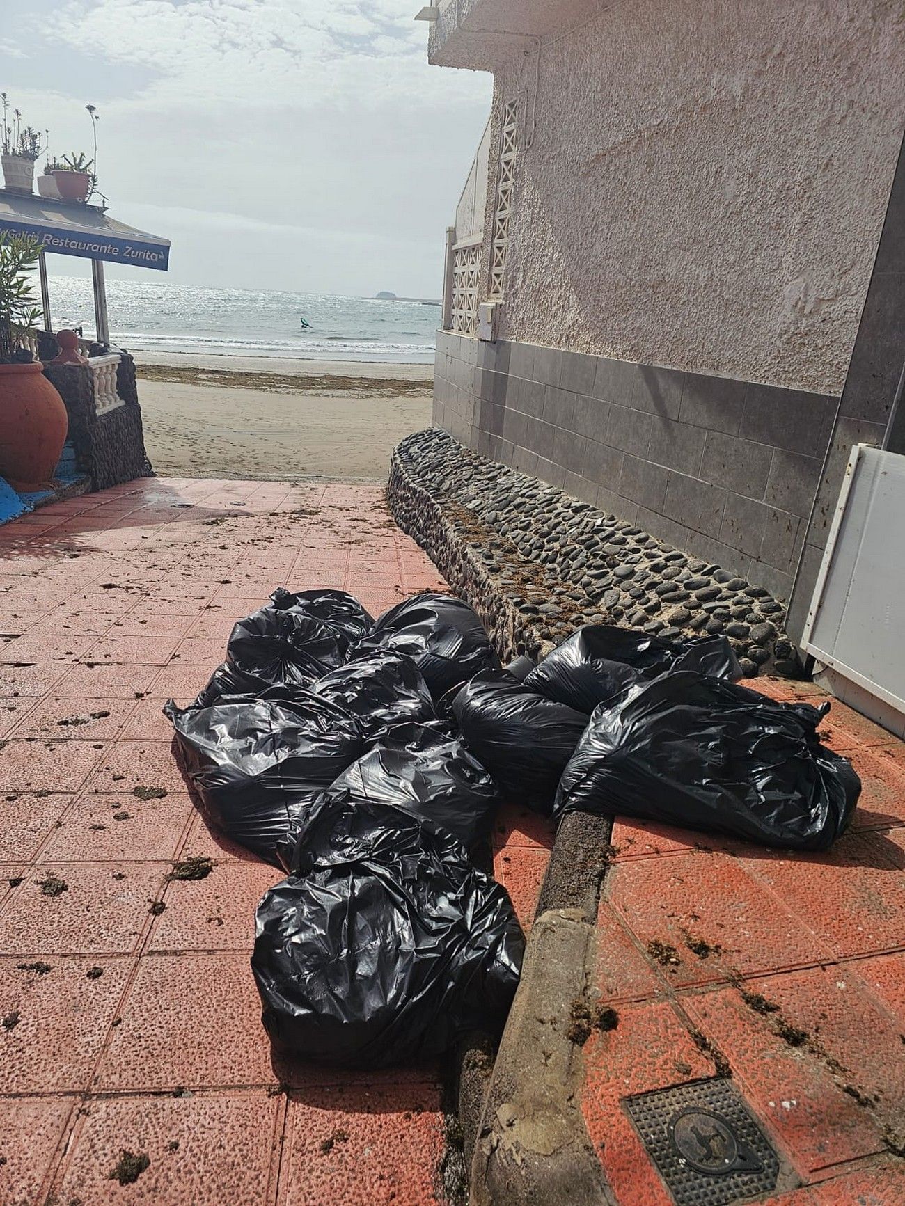 Limpieza intensiva en Ojos de Garza tras la acumulación de piedras, ceba y arena por la subida de la marea