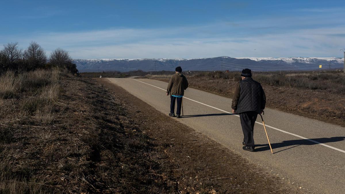 Dos personas mayores pasean por una carretera cerca de la localidad zamorana de Otero de Sanabria.