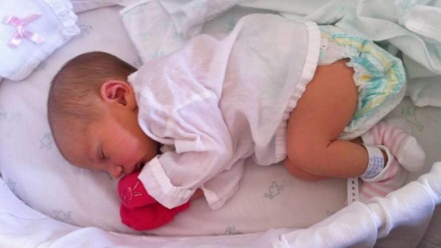 Una recién nacida con la ropa del hospital en la Arrixaca.
