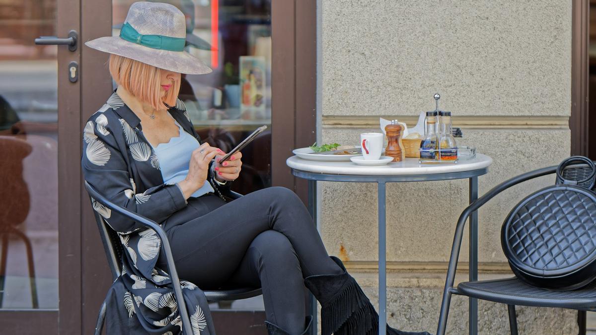 Una mujer sentada en la terraza de un bar, en una imagen de archivo