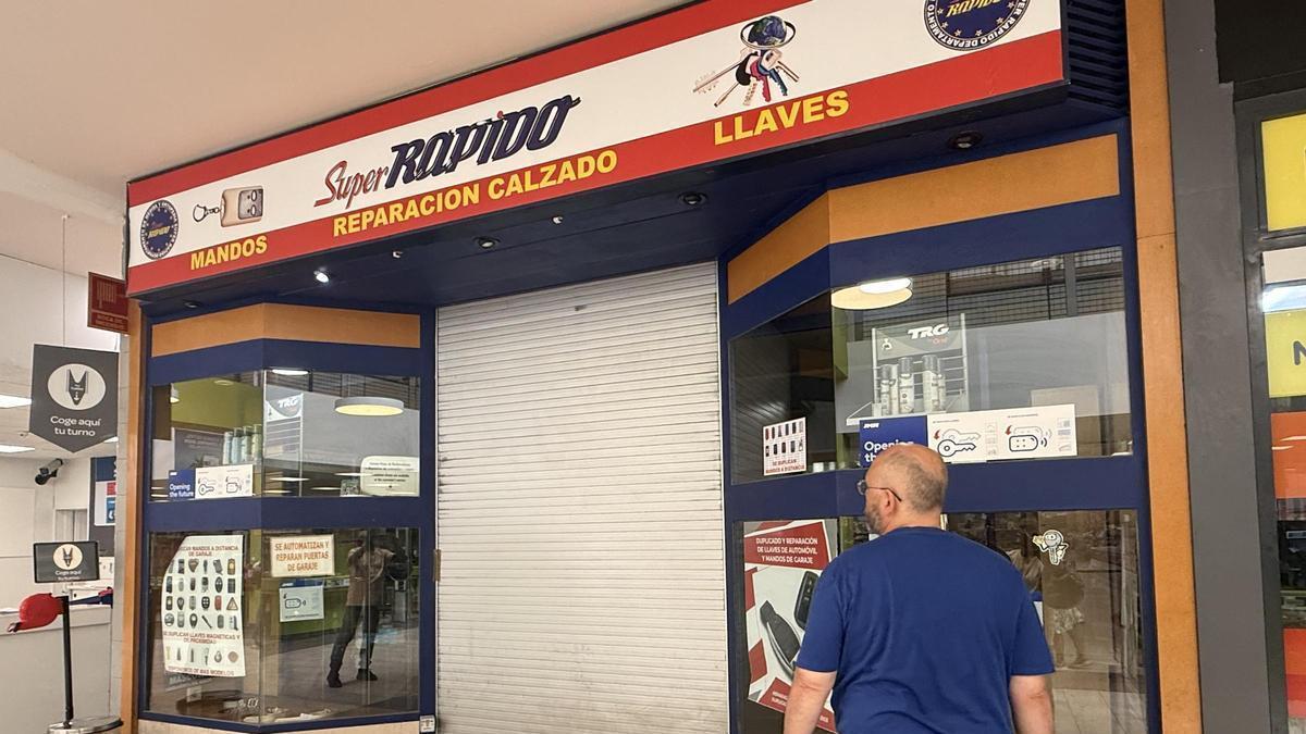 Un hombre, este jueves en el exterior de la tienda de reparación de calzado donde fue asesinada Gloria a manos de su ex.