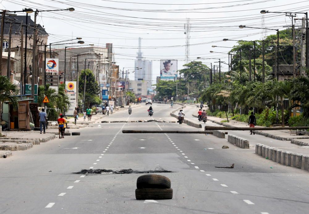 People walk along a blocked road in Lagos