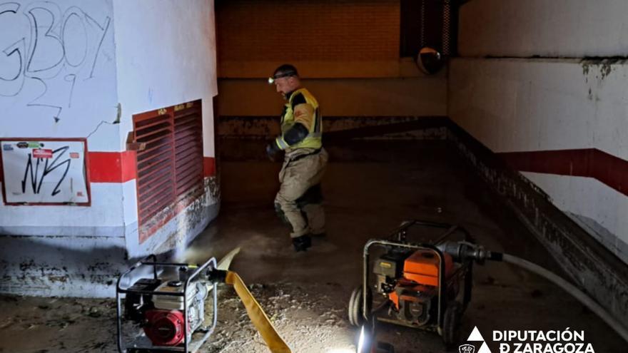 Los bomberos de la DPZ trabajan dentro de un garaje completamente inundado