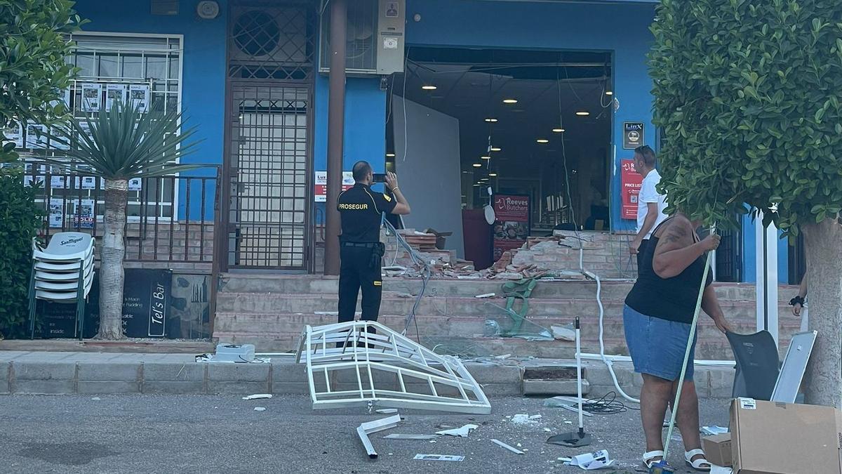 Un vigilante de seguridad hace una foto al destrozo dejado tras arrancar el cajero en agosto en la misma oficina de Camposol.