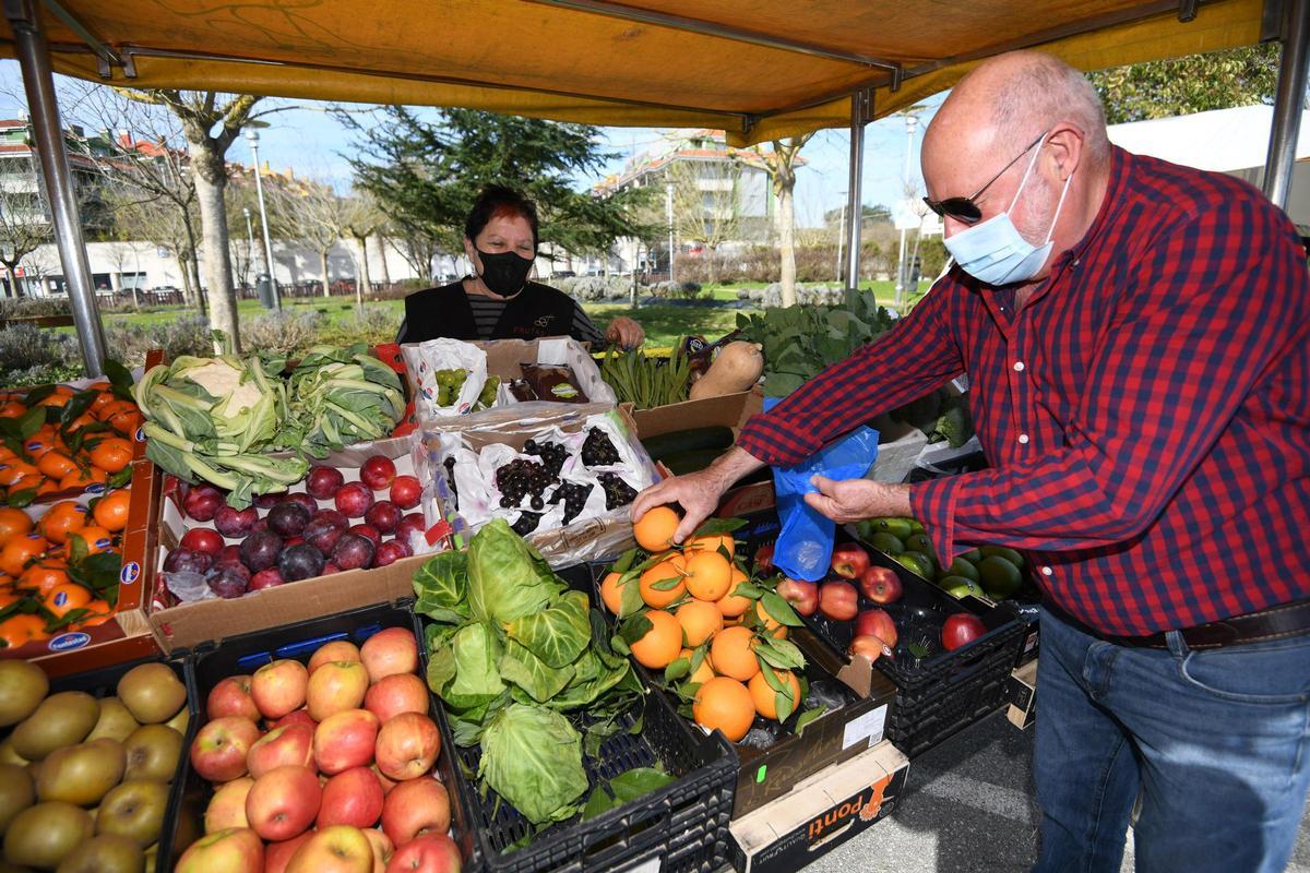 Mari Barreiro, vendedora en el mercadillo desde hace 32 años, atiende a un cliente
