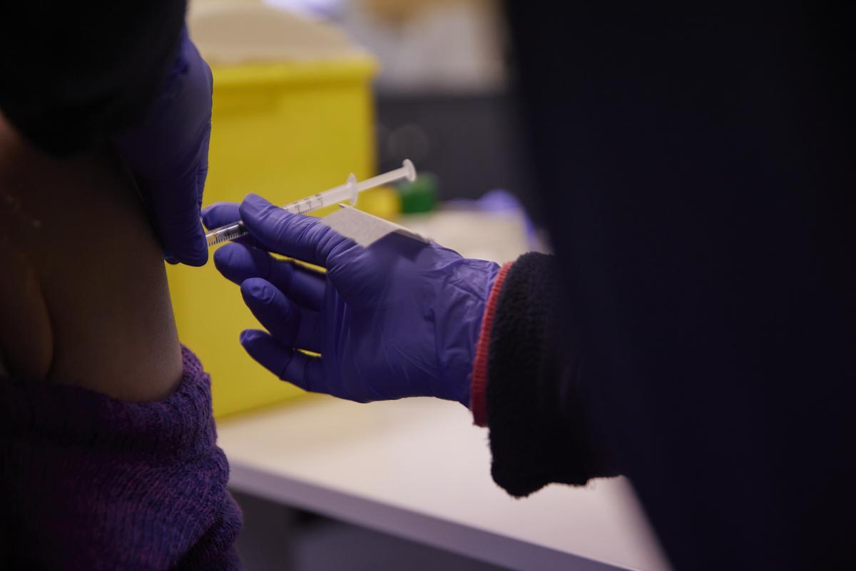 Detalle de una persona recibiendo  la tercera dosis de la vacuna contra el Covid-19 en el Centro de Salud Pavones en Madrid (España).