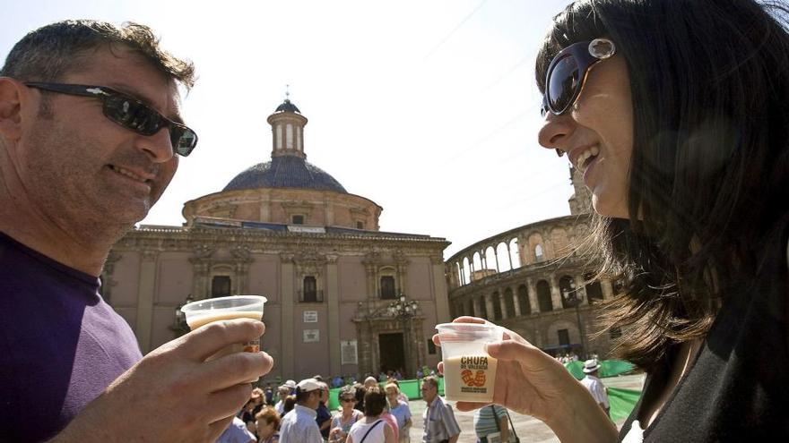 Una pareja degusta la horchata valenciana en la plaza de la Virgen de Valencia