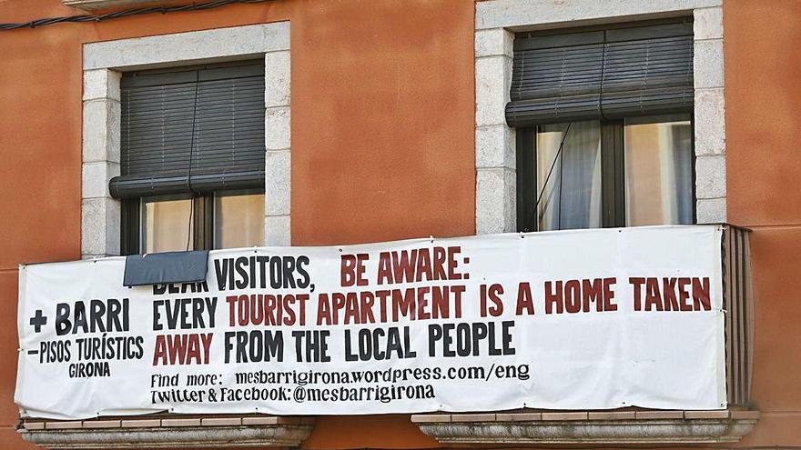 Pancarta contra la proliferació de pisos turístics al Barri Vell de Girona.