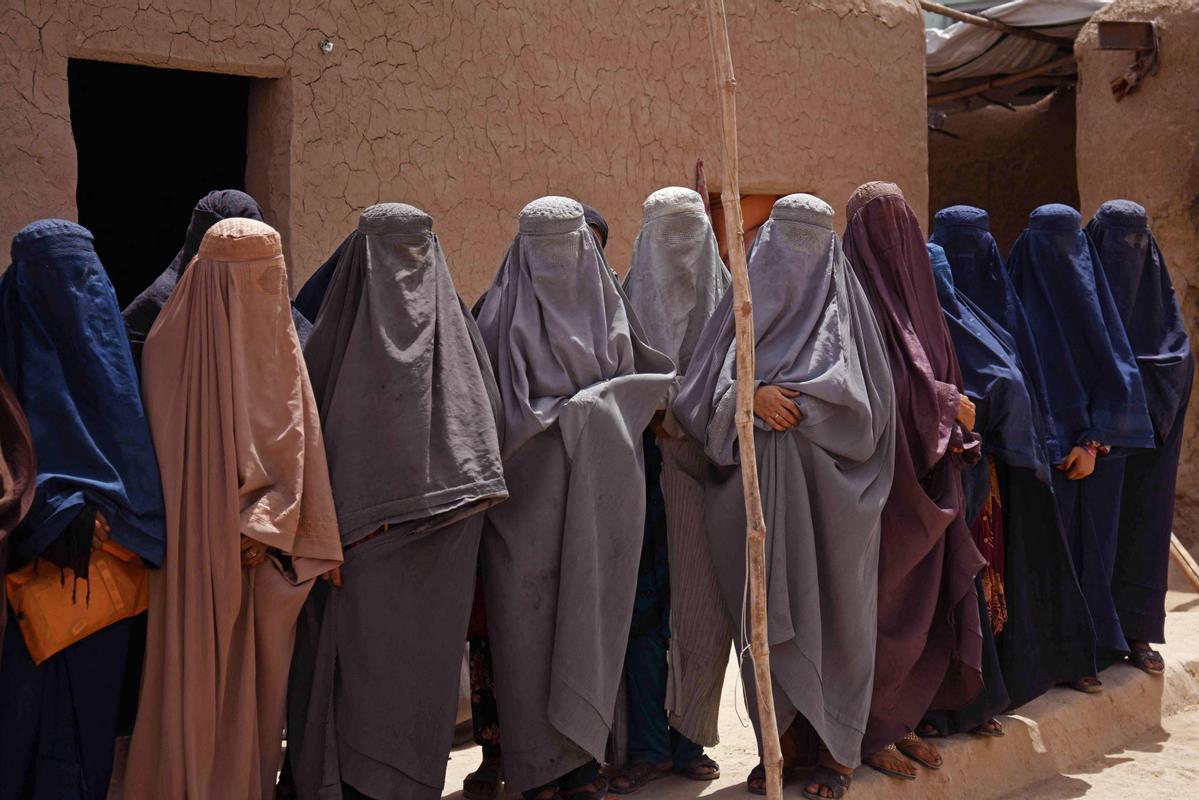 Afganas con burka trabajando en una fábrica de jabón y ropa en Kandahar