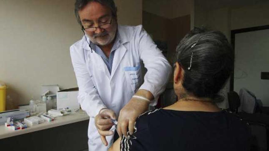 Un sanitario inyecta la vacuna de la gripe a una paciente en un  centro de salud de Zamora.