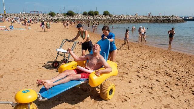 Iván saliendo del mar en una de las sillas anfibias en la playa de Oza. |  Casteleiro/ Roller Agencia