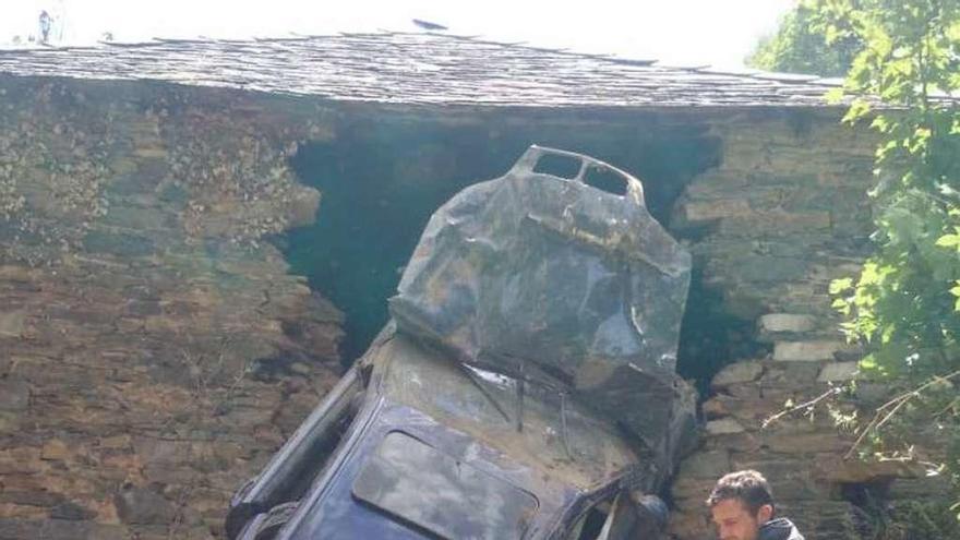 Un bombero junto al coche accidentado.