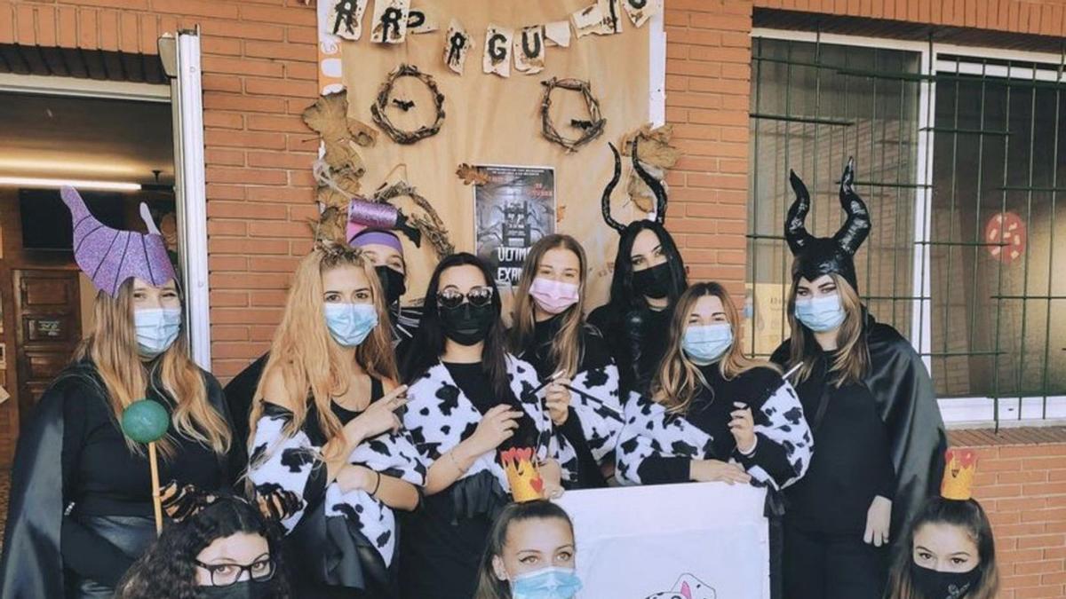 A la izquierda, alumnos del Institutu Roces, amarutaos el xueves pasáu. Enriba estes llinies, delles puertes del centru escolar, decoraes con motivos de Halloween. | LNE