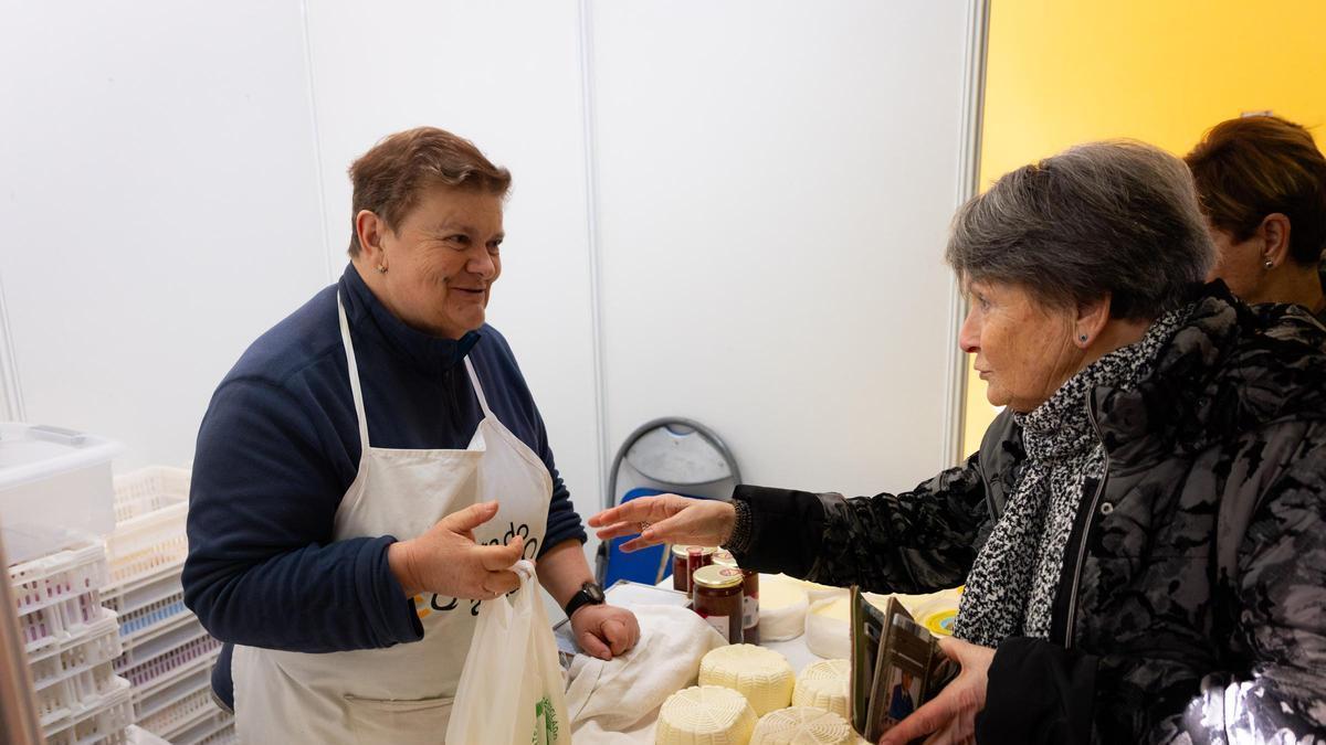 Una mujer compra queso en la Festa do Queixo de Arzúa
