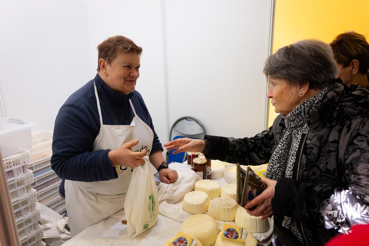 Una mujer compra queso en la Festa do Queixo de Arzúa