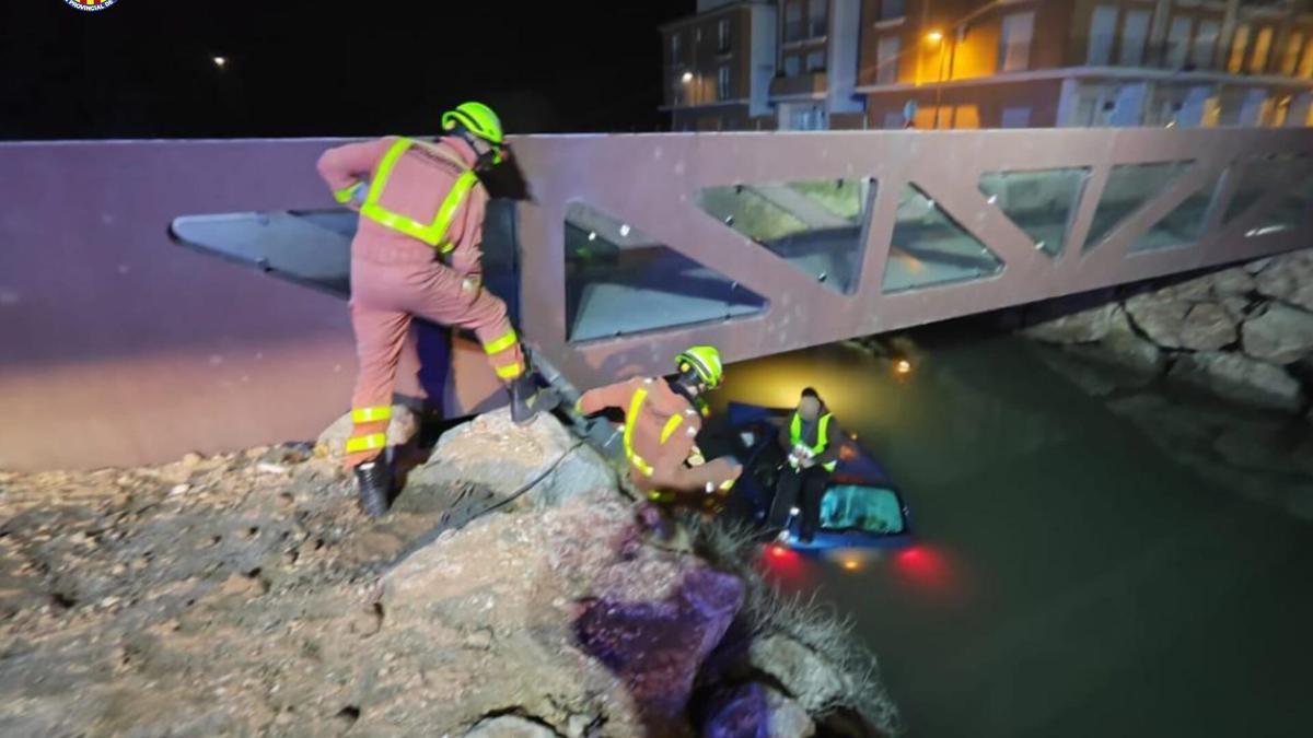 Los bomberos rescatan al hombre que cayó con su coche a un canal de Sollana.