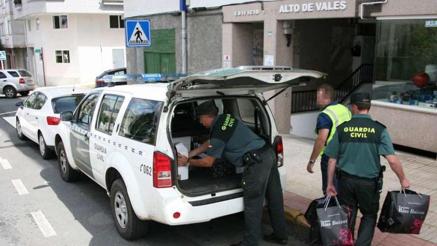 Agentes guardan en un vehículo diverso material del registro en la sede de Prosem. // Bernabé/Luismy