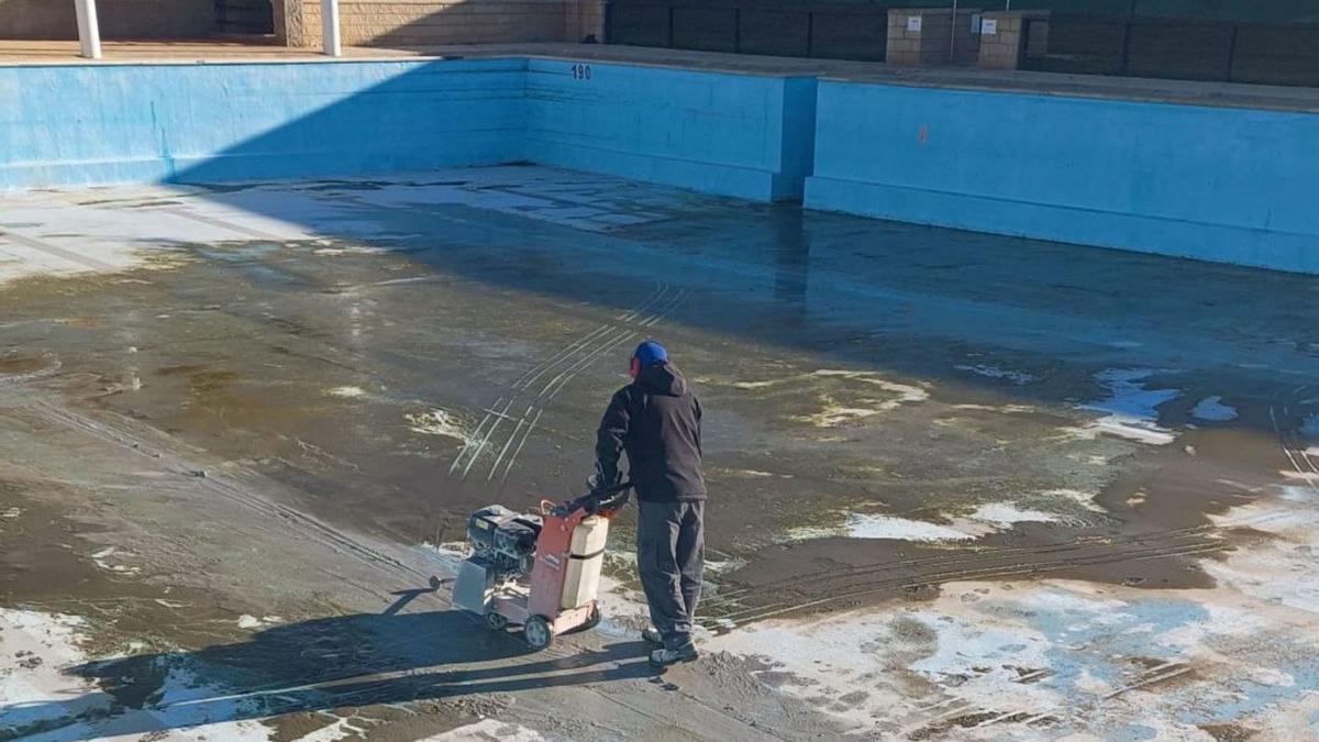 Un operario de la empresa adjudicataria trabaja en la reforma del vaso de la piscina de adultos. | Cedida