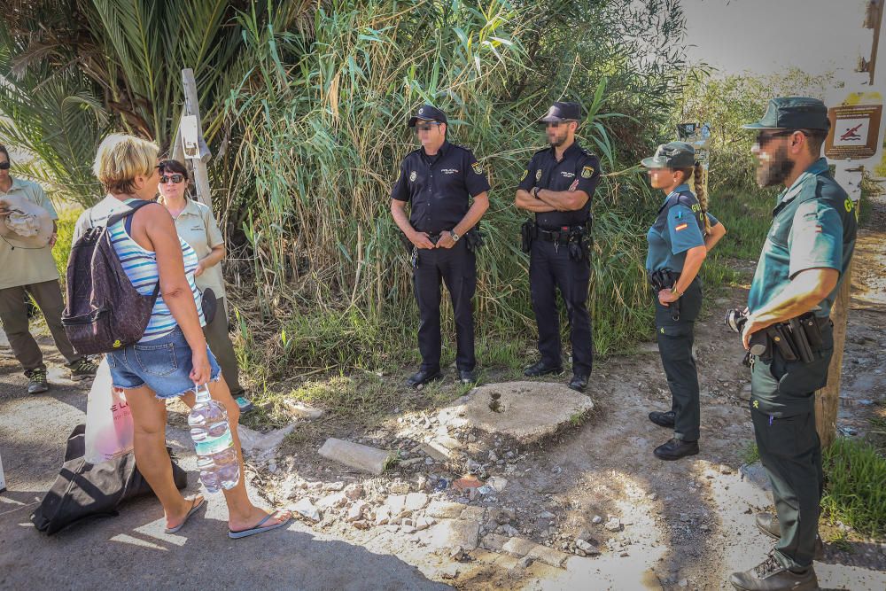 Guardia Civil y Policía cierran el paso a los bañistas en la laguna de Torrevieja. El personal del parque natural y agentes ambientales de la Generalitat informan sobre la prohibición de baño