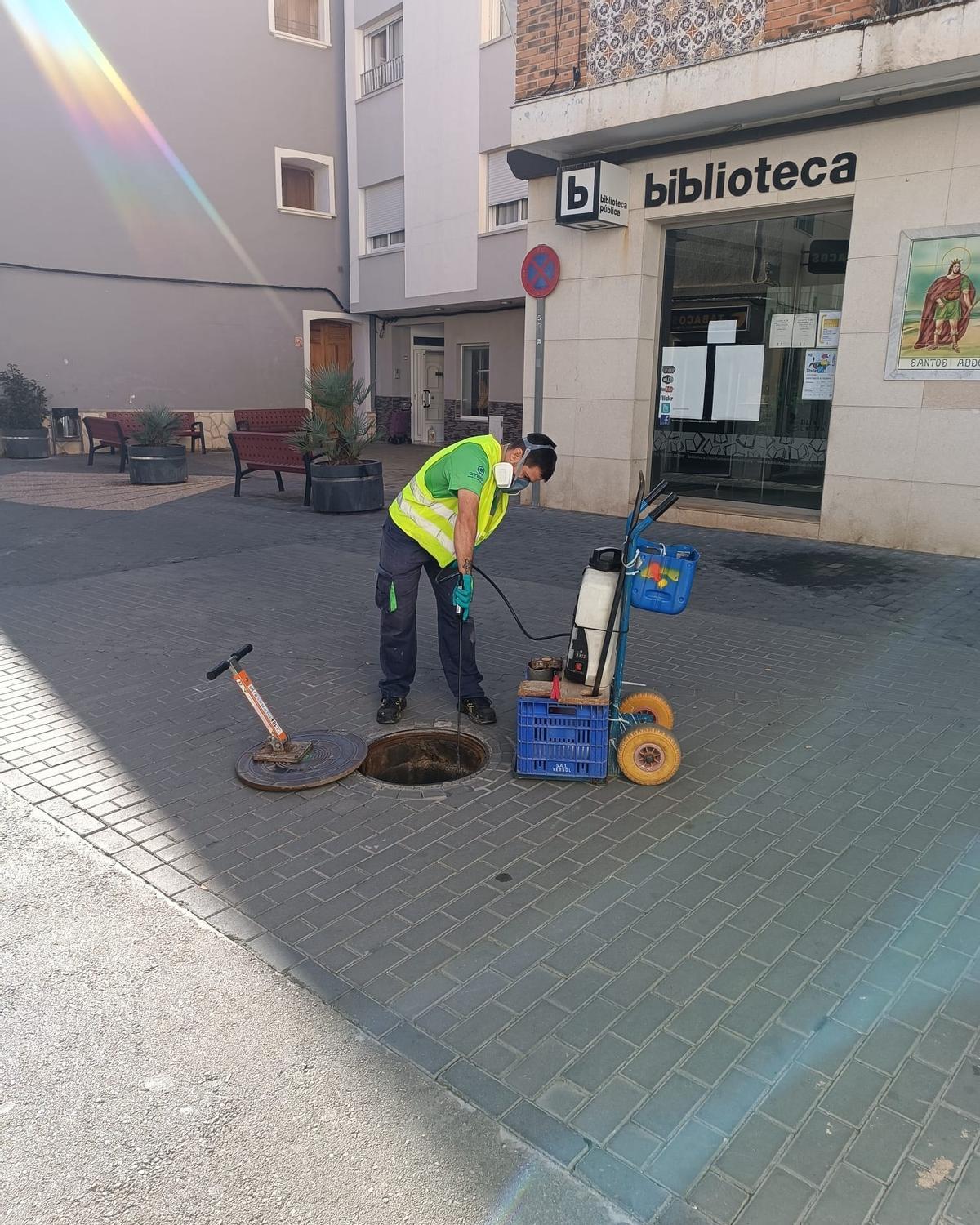 Operarios aplicando tratamientos contra las plagas en la red de alcantarillado de l'Olleria.