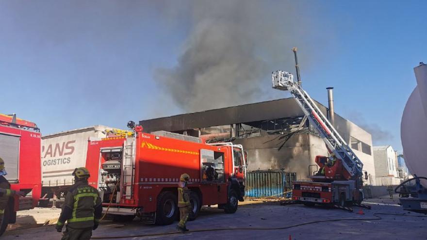 Pla general de l&#039;empresa afectada per un incendi al polígon de l&#039;Arboç (Baix Penedès) i els Bombers treballant-hi amb un camió grua