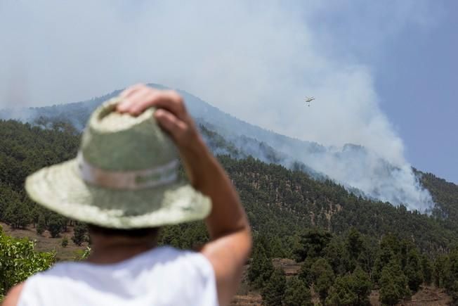 A resident watches the smoke from a fire in Las ...