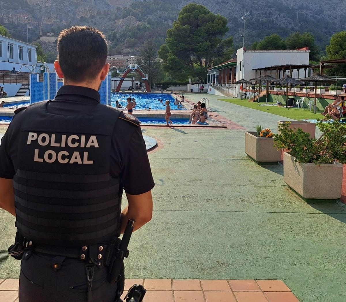 Un agente vigila una piscina municipal en Alcoy