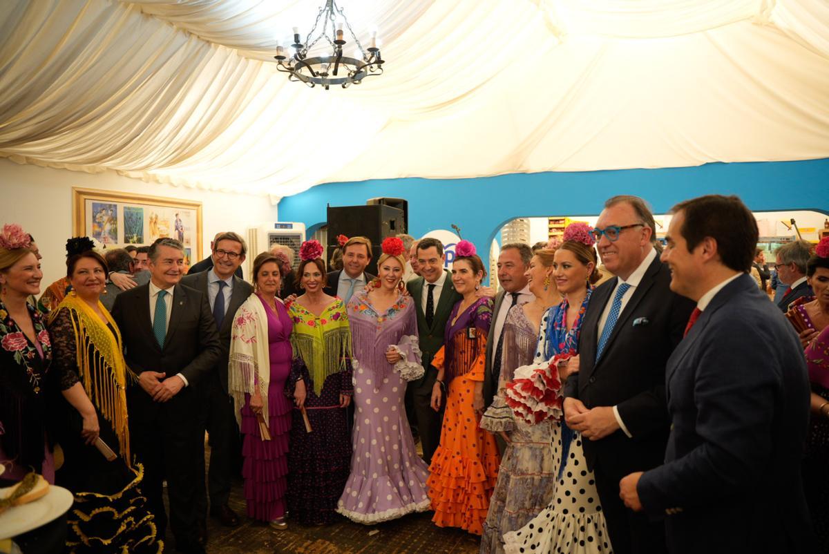 El presidente de la Junta de Andalucía, Juanma Moreno preside la foto de familia en la visita a la caseta del Partido Popular en el  Real de la Feria