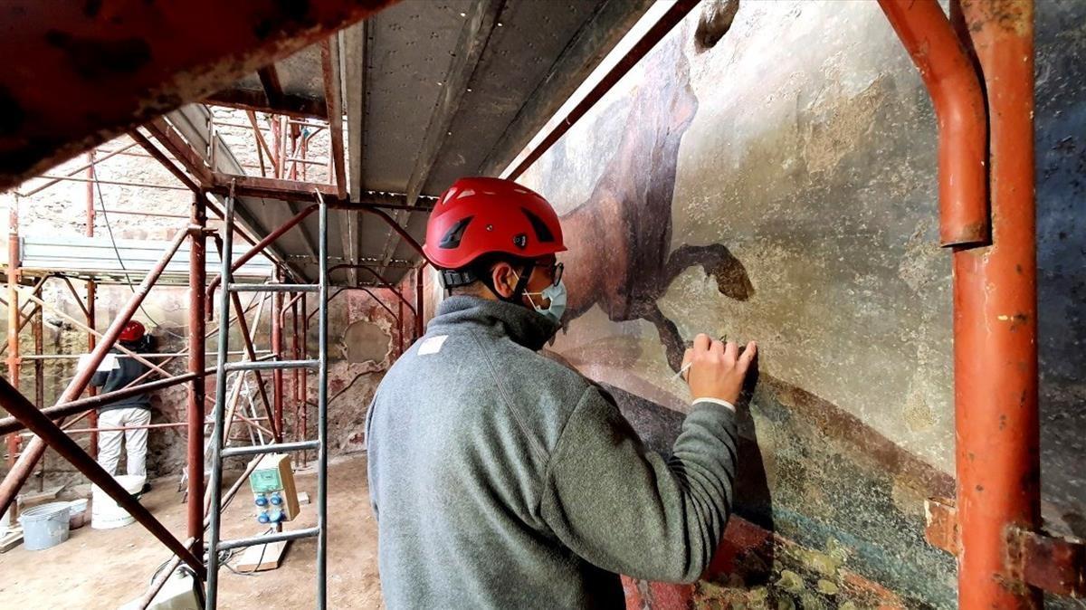 Labores de restauración del fresco de grandes dimensiones con motivos egipcios, como animales y poblaciones del delta del Nilo, situado en el jardín de la casa de los Ceii, un magistrado de la Antigua Roma, en Pompeya.