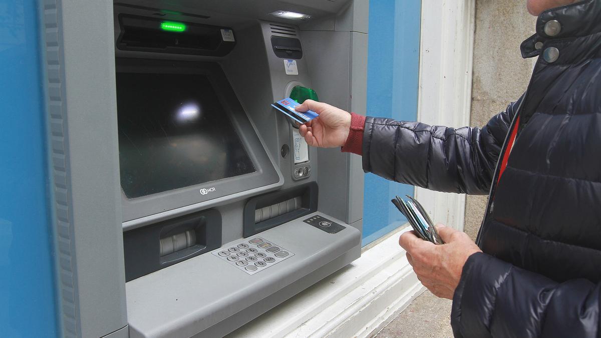Un hombre saca dinero en el cajero automático de un banco.