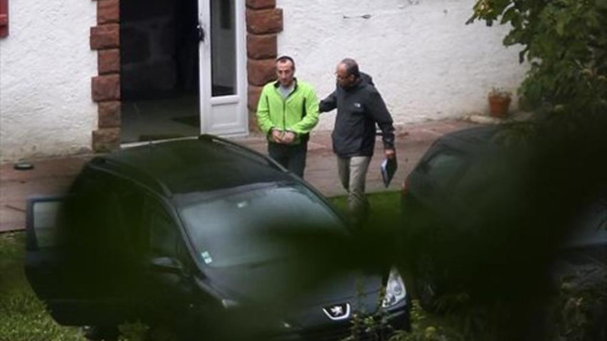 Un agente de la policía francesa se lleva detenido a David Pla en la casa de turismo rural de Baigorri en la que fue detenido junto a Iratxe Sorzabal.