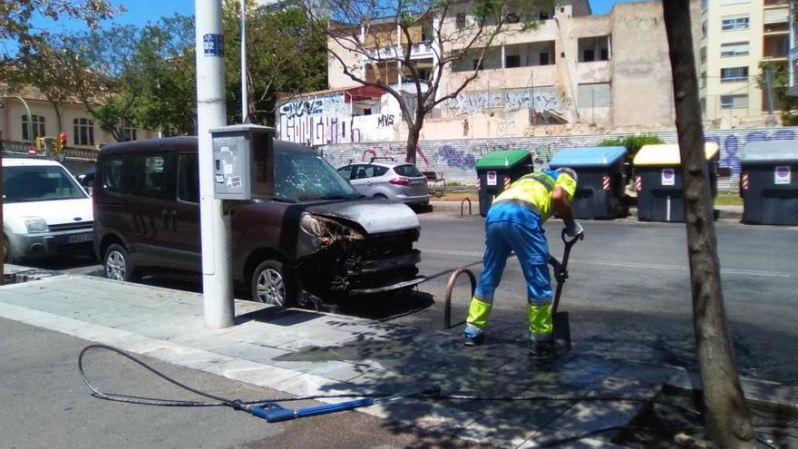 Un trabajador de Emaya limpia restos de un contenedor quemado.