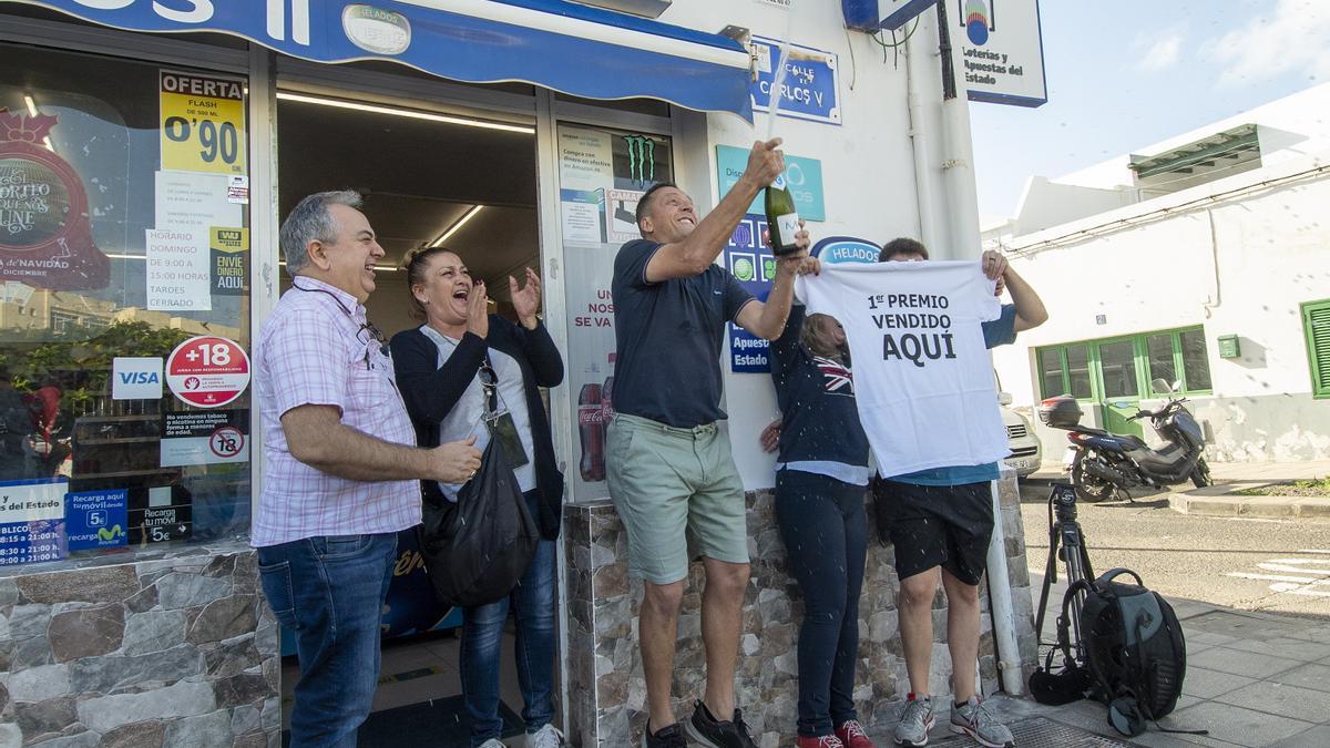 Enrique Gandul, responsable del Bazar Juani, descorcha una botella de champán para celebrar que vendió un décimo del Gordo.